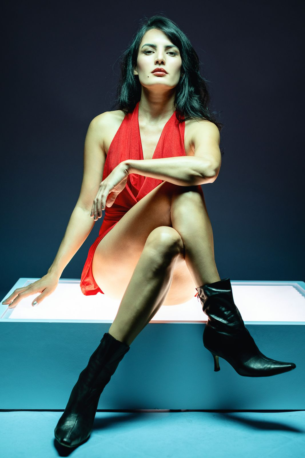 Portrait in a red dress seated on a light box