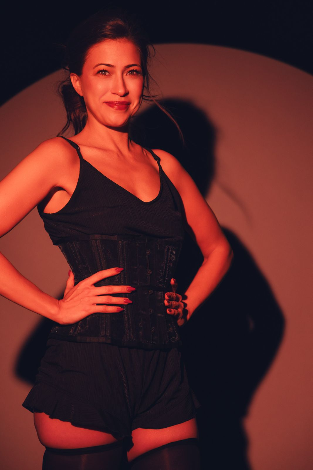 Smiling portrait in a corset under red light